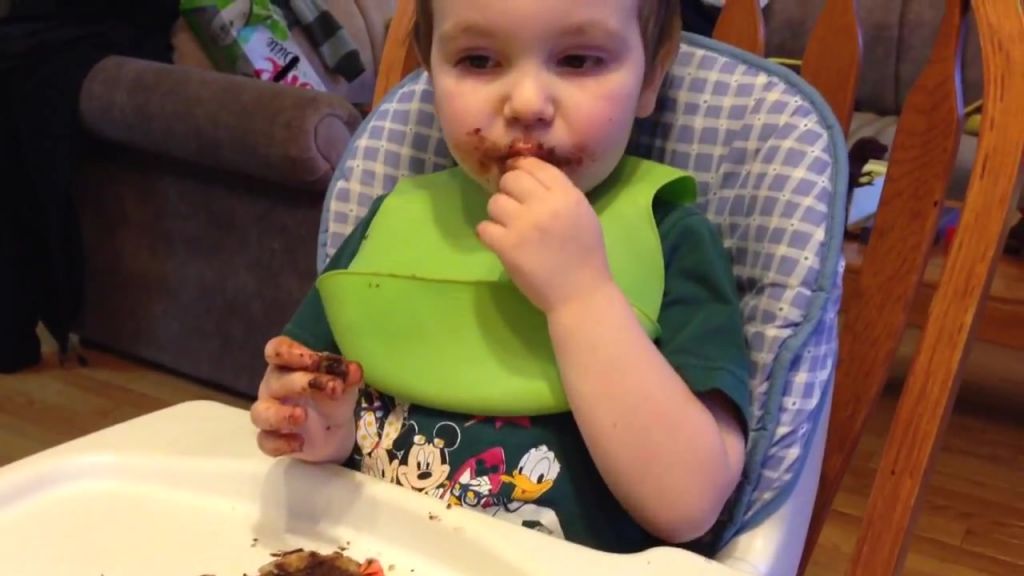 Маленький ребенок кушает шоколад